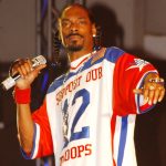 Snoop Dogg, holding a mic with rhinestones, from the Plush Recording Studios website.